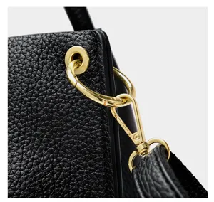Detailed shot of women's black soft leather handbag shoulder crossbody bag metal hardware.