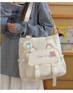 Close-up detail of cute cat ear canvas shoulder bag, large capacity student crossbody bag.
