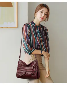 Stylish wine red PU leather crossbody bag worn by model, multi-pocket design, versatile daily use.