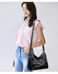 Detailed view of a black PU leather shoulder bag worn by a model, featuring multi-pockets.