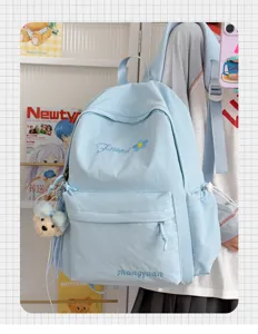 Details of the light blue student casual backpack showing front pocket, cute pendant and embroidery.