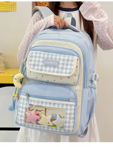 Detailed view of the cute blue grid student backpack with transparent ita window and charms.