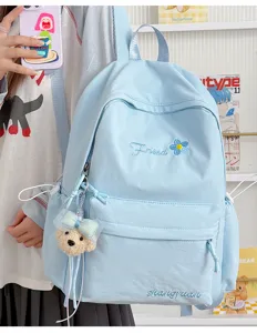 Detailed view of the Japanese solid color casual backpack with cute bear pendant and embroidery.