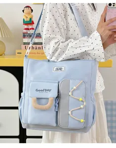 Primer plano del bolso de lona azul claro con múltiples bolsillos y detalles útiles.