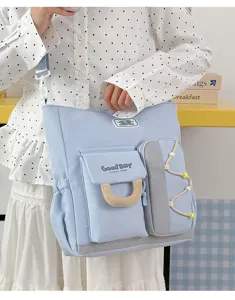 Primer plano del bolso cruzado azul claro con múltiples bolsillos que muestra el bolsillo delantero.