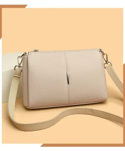 Detail view of a stylish beige PU leather crossbody bag with simple design and metal decor.