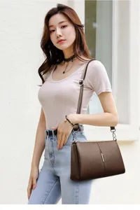 Close-up detail view of the brown leather shoulder bag worn by a model in daily casual styling.