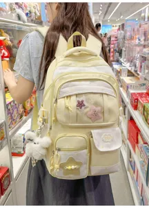 Detailed view of the yellow star backpack featuring multi-pockets and plush charms.