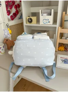 Cute star print school backpack detail view on desk, light blue canvas casual daypack.