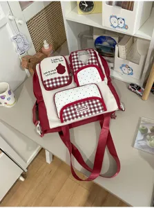 Detailed view of red and white canvas tote backpack with multiple storage pockets and cute design.