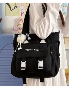Close-up detail of cute black cat canvas shoulder bag with lovely ears and white buckles.