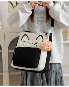 Detail shot of the cute cat canvas tote bag with contrast colors and plush bear charm.