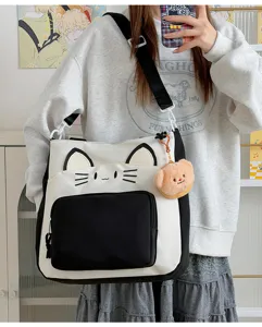 Details of the cute cat canvas tote bag with contrast color and plush bear pendant for daily use.