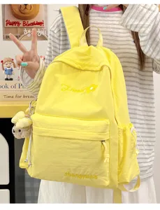 Yellow canvas backpack detail view featuring cute flower embroidery and side pocket design.