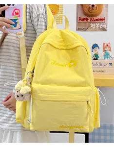 Casual yellow canvas backpack for college students, featuring cute bear pendant and style.