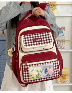 Red and white plaid student backpack featuring a clear ita front pocket and cute star accessories.