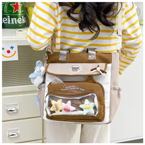 Cute large capacity student canvas shoulder bag with clear front pocket and adorable plush pendants for school.