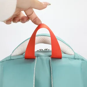 Close-up detail of teal backpack top handle, durable orange strap, breathable mesh design.