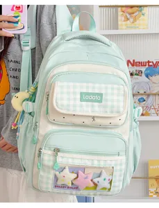 Detail shot of a mint green student ita bag with clear window, multi-pockets, and cute star plushies.
