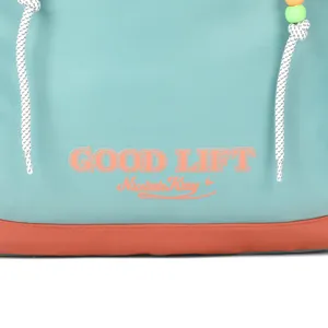 Teal backpack detail shot featuring custom text print, contrast bottom and beads.