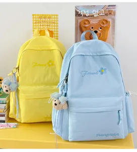 Detailed view of casual canvas backpack with cute bear pendant and floral embroidery.