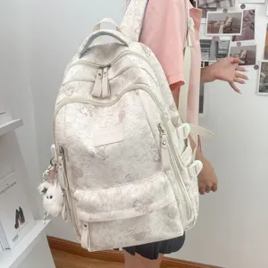 Stylish multi-compartment canvas backpack with cute bear print for daily school use.