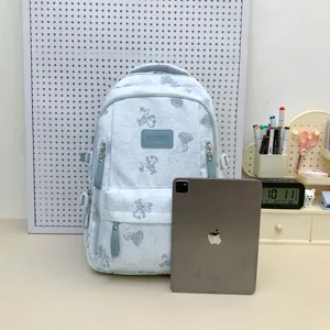 Detail view of light blue bear print school backpack with multi compartments and patch.