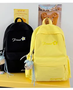 Detailed view of casual solid color canvas backpack with cute embroidery and hanging pendant.