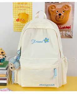 Casual solid color canvas backpack for women students, cute design with embroidery and charm.