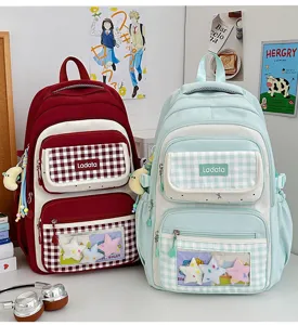 Detail view of grid school backpack with clear window pocket and cute plush star pendants.