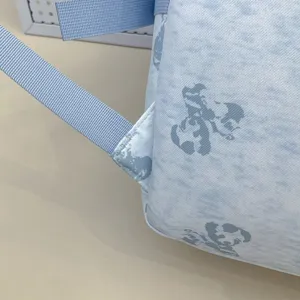 Light blue backpack detailed view with cute cartoon character print, durable student school bag.
