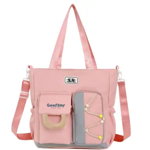 Gran bolso de hombro rosa de lona con múltiples bolsillos para el viaje escolar diario.