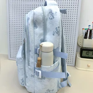 Side close-up view of light blue school backpack with cute bear print and side pocket.