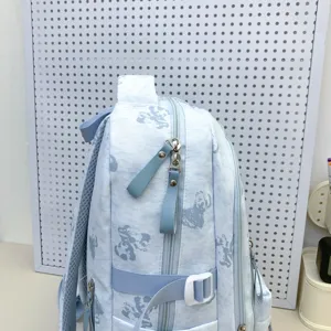 Light blue school backpack with cute bear print, multi-compartment design for students.