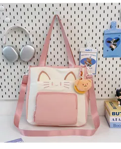 Cute pink and white cat face embroidered canvas tote bag, detail shot with cute bear charm.