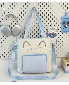 Detail view of the cute cat-themed canvas tote bag in color block, featuring shoulder straps and front pocket.