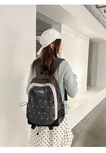 Detailed view of the stylish grey student backpack with cute blue hearts and white trim design.
