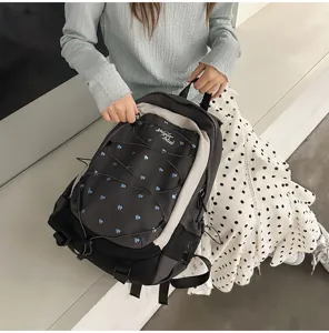 Detailed view of the girls sweet cool style backpack with heart prints and drawstring.