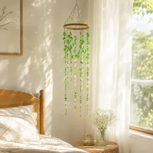 Detail view of green leaf wind chime hanging in a warm bedroom with sunlight ref.