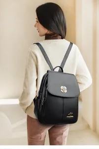 Details of black soft leather women backpack with metal clover lock and side view.