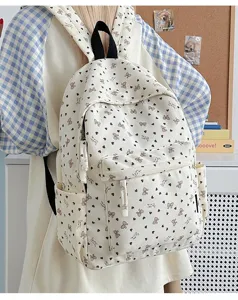 Corduroy backpack close-up view showing cute bow and heart print pattern design details.