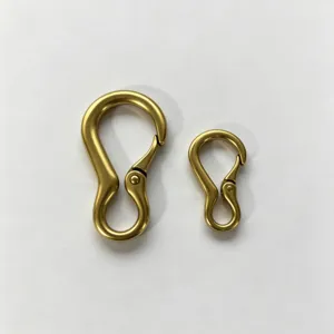 Primer plano detallado de mosquetones de resorte de metal bronce vintage, dos tamaños accesorios.