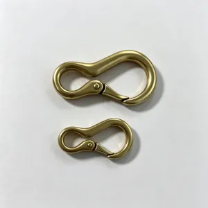 Primer plano de dos mosquetones de metal color latón, ganchos utilitarios para accesorios.