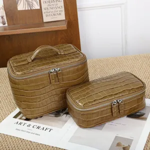 Detalle de bolsa cosmetica de piel vacuna con patron de cocodrilo, gran organizador.