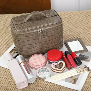 Bolso cosmético marrón de piel auténtica de cocodrilo con detalle de gran capacidad.