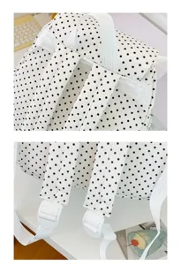 Primo piano dettagliato di un dolce zaino a pois vintage con spallacci e fibbie regolabili.