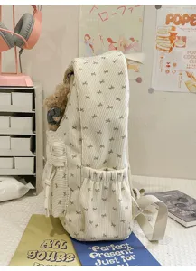Close up of cute corduroy bow backpack side pocket detail with adorable plush bear pendant.