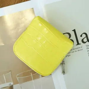 Detailed view of bright yellow crocodile pattern leather zipper coin purse and jewelry pouch.