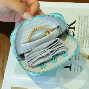Leather jewelry organizer pouch detail view, portable coin purse and card holder with zipper.