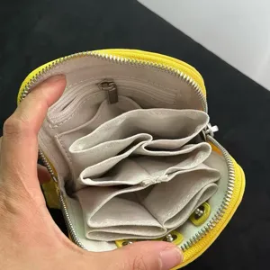 Detail view of yellow leather zipper coin pouch showing multiple inner accordion compartments.
